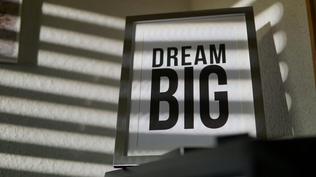 Framed motivational 'Dream Big' text art creates an inspiring indoor ambiance.